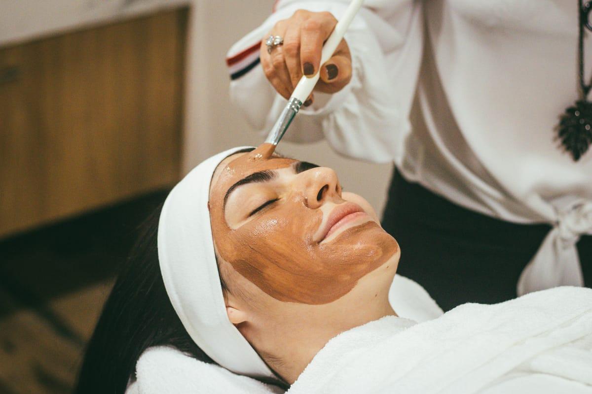 Aesthetician applying a facial treatment in a calm clinic setting